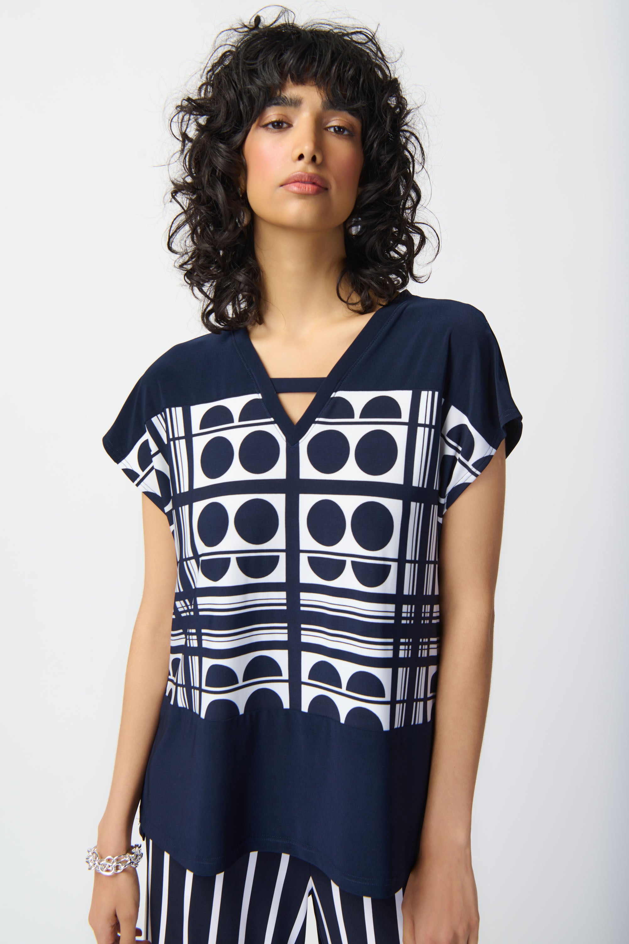 Elevate your look effortlessly with this lovely geometric printed top. The short raglan sleeves and V-shaped neckline lend a relaxed fit for everyday wear and give character to this contemporary piece. The side seam slits at the sweep add a subtle chic detail that also allows for easy movement.