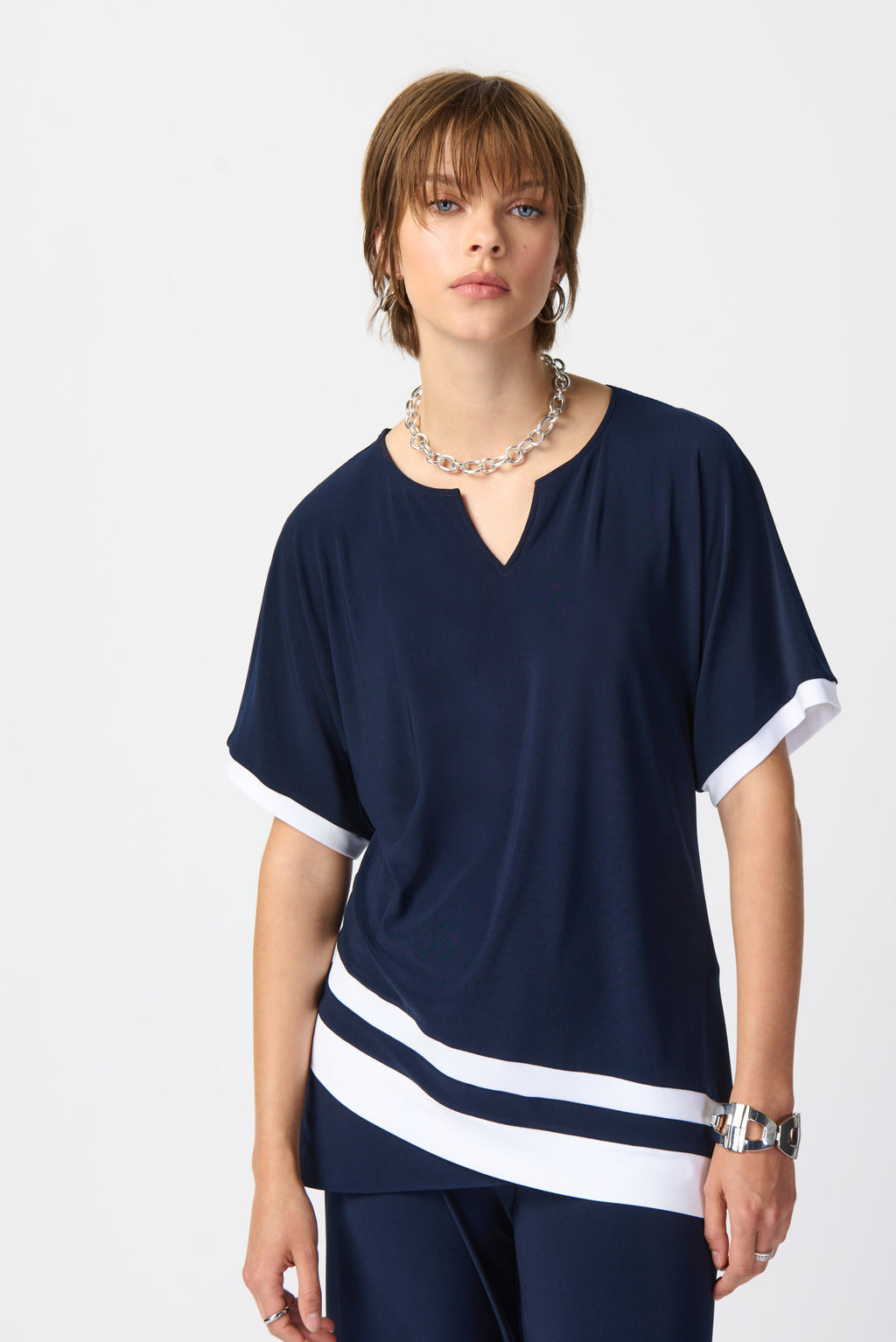  Add a touch of sophistication to your wardrobe with this unique colour-block top. This short-sleeve design features a flattering slit neckline that adds elegance and versatility to the overall look.