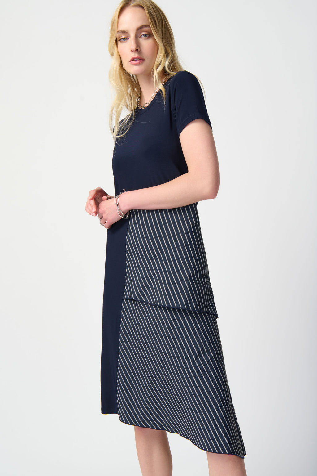 This unique silky knit dress exudes refinement and confidence. Crafted with a beautifully striped memory asymmetrical hem, this trapeze dress will make a subtle yet striking addition to your wardrobe. Featuring a crewneck and short sleeves, it is the perfect piece to stand out on any occasion.