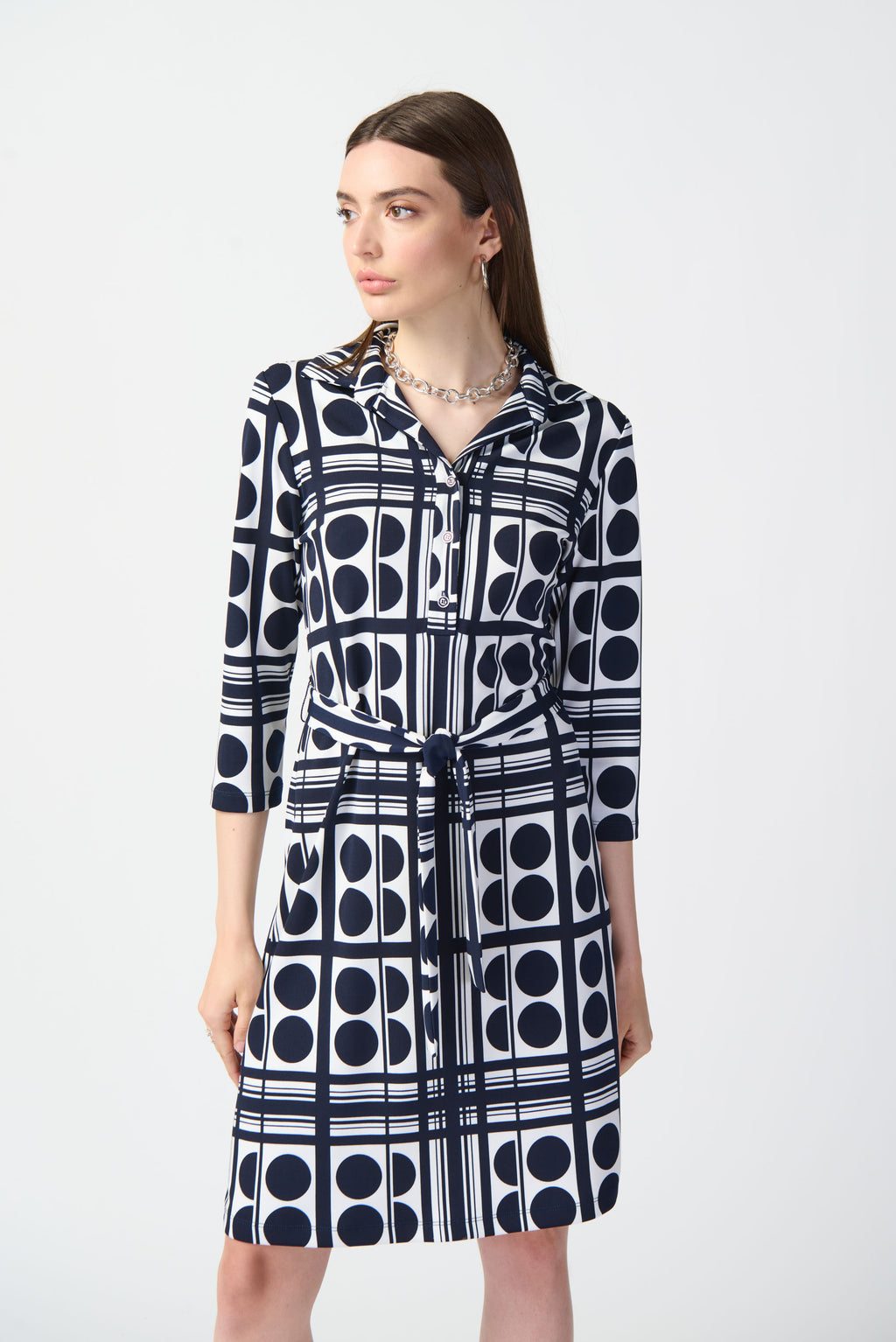 Indulge in effortless elegance with this luxurious dot-printed shirt dress. Made from premium, silky knit, it offers a comfortable, sophisticated look that transitions seamlessly from day to night. The elegant front placket and crisp collar lend a touch of refinement, while the three-quarter sleeves and cinching sash waist create a flattering silhouette.