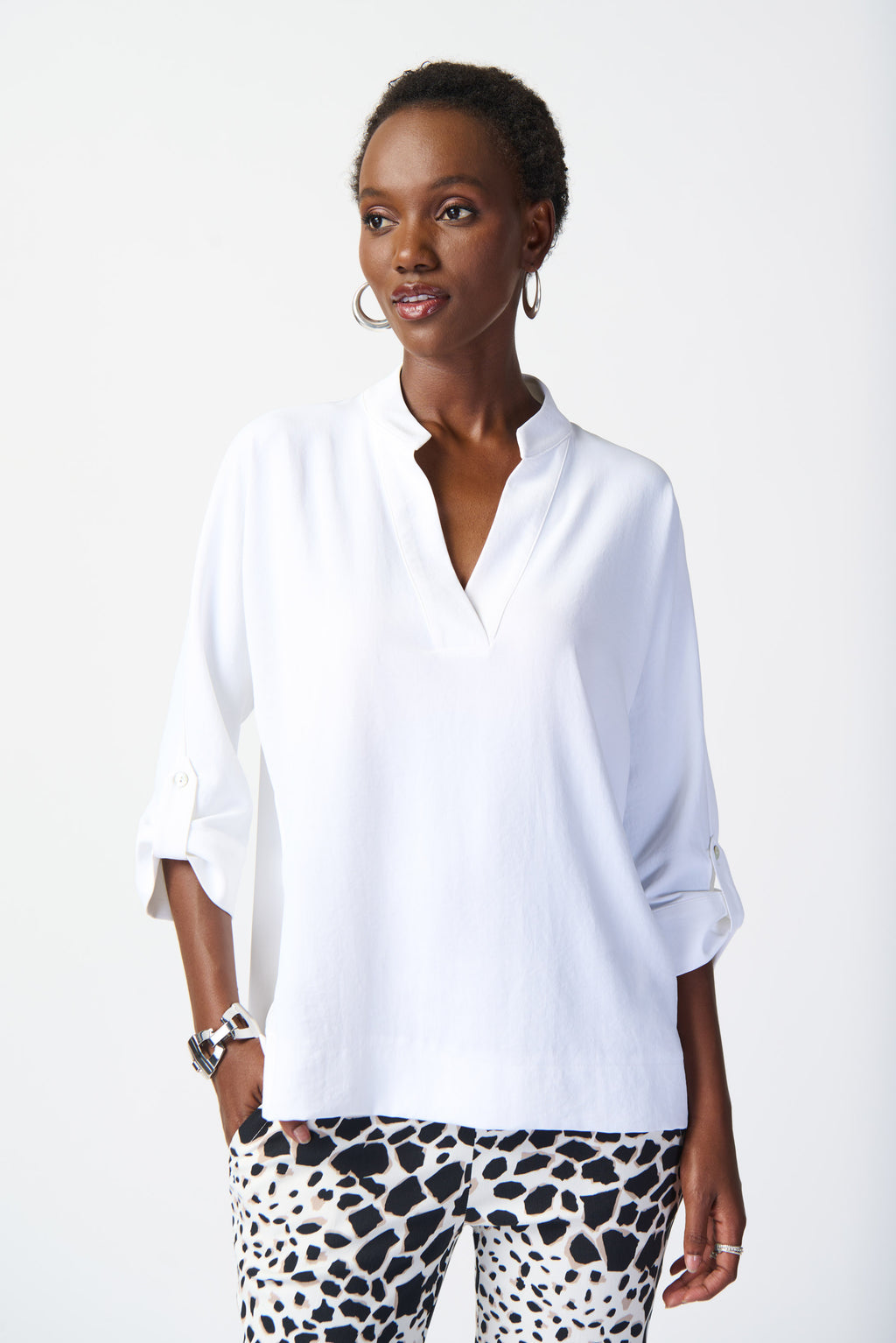 Tailored in a loose relaxed fit, this woven knit top can effortlessly be styled from day to night. The mandarin collar adds poise to this contemporary design and the three-quarter dolman sleeves adorned with cuffs and tabs elevate the garment’s boxy silhouette and understated chic appeal.