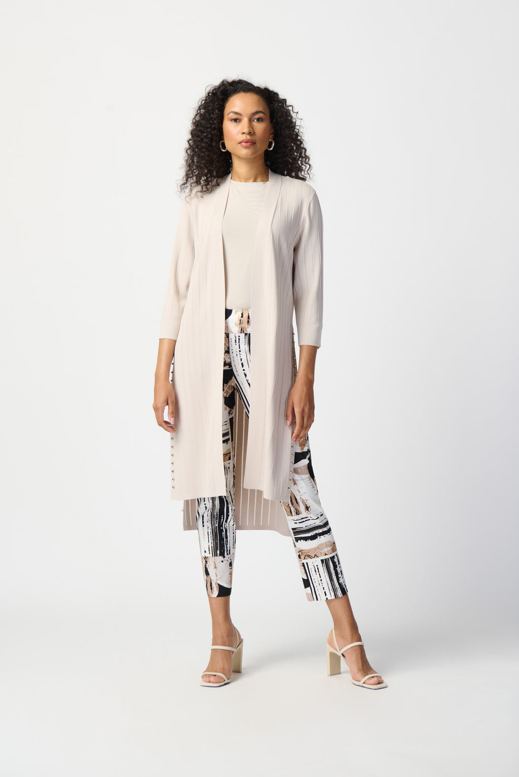 Choose an expressive look with this lightweight light beige textured cover-up/cardigan that has long side slits and bell sleeves to create movement and flow as you walk. The stud detailing along the slits gives it an edgy yet classy look for work or leisure.