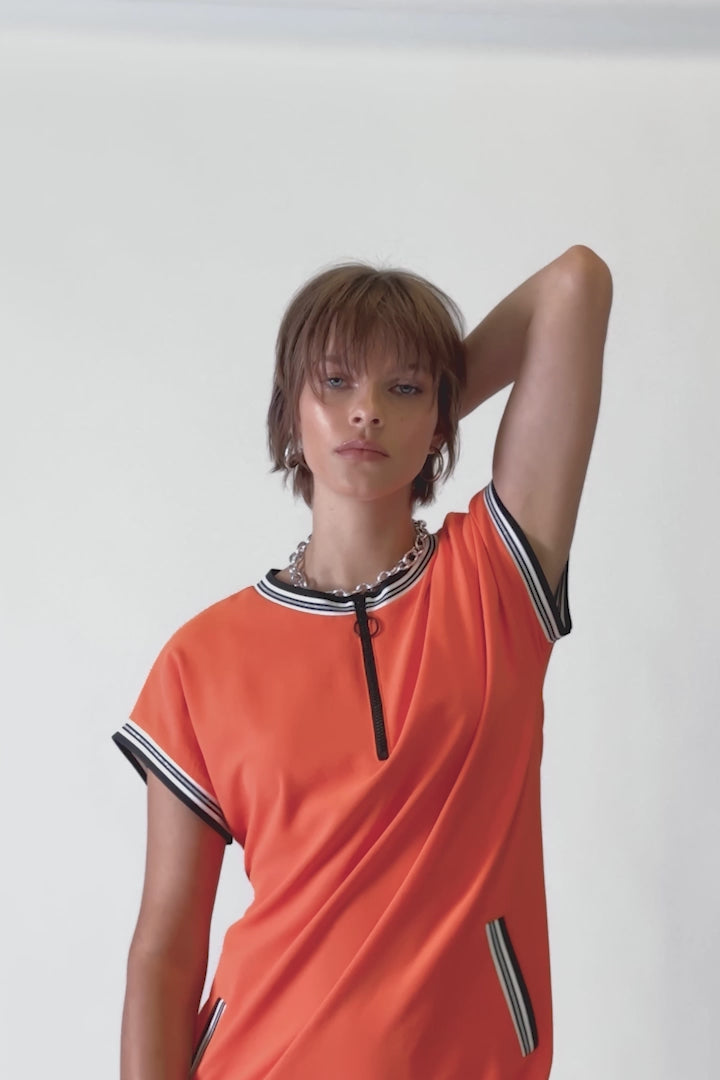 Short dolman sleeves and a flowy woven fabric make this dress chic and versatile. Finished with ribbed trims at the crew neck and sleeve hem, and a front welt pocket, this zipped neckline dress is an essential piece that you'll turn to time and time again. In a stunning mandarin colour